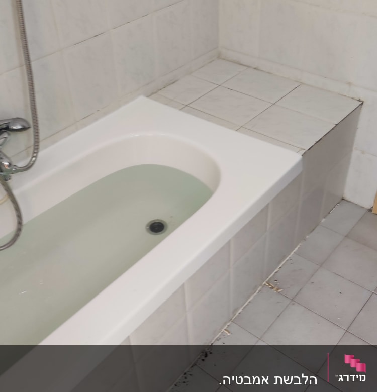 אמבטיה עם חיפוי אריחים לבנים על הקירות והרצפה